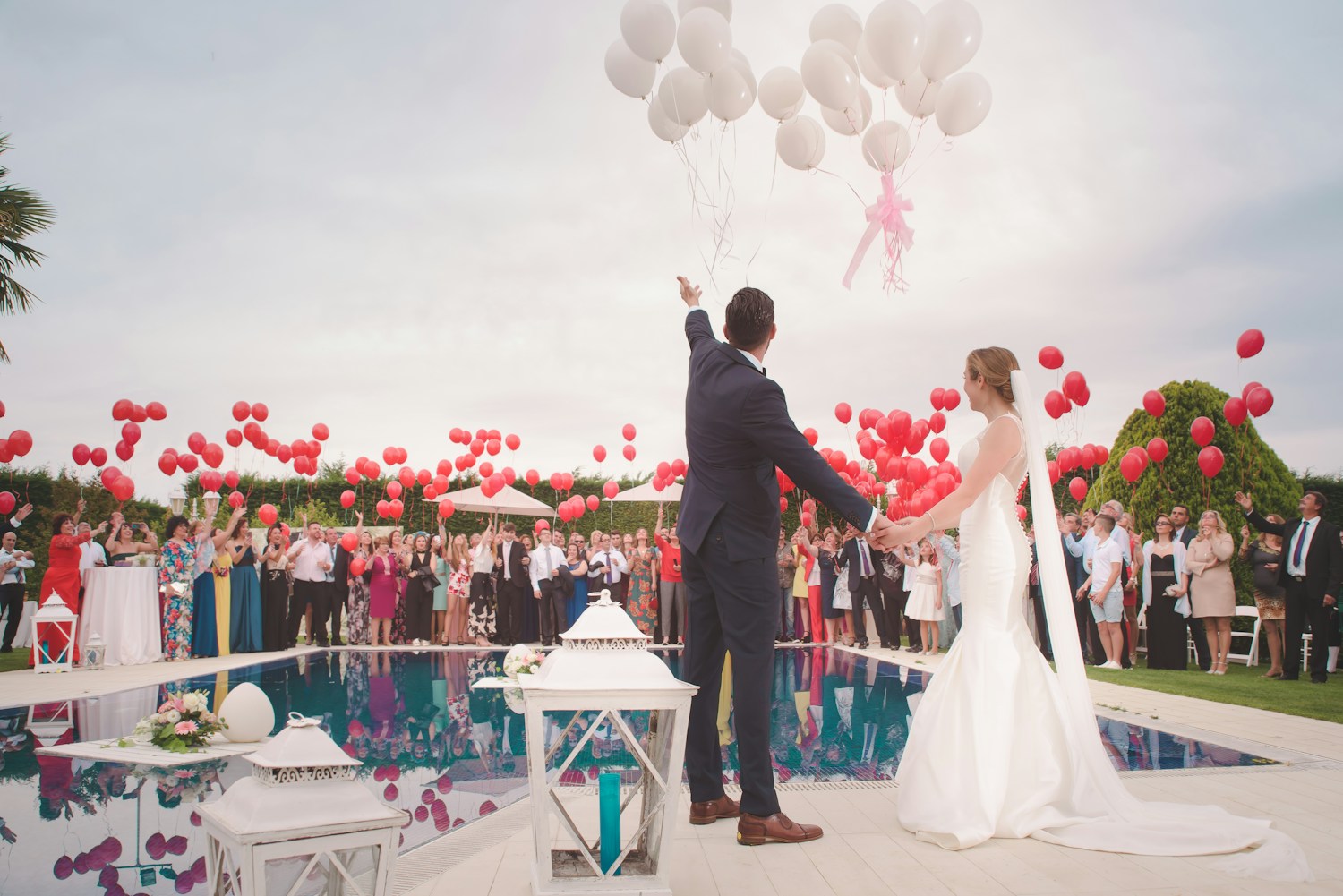 Wedding celebration with a couple, guests, and floating balloons